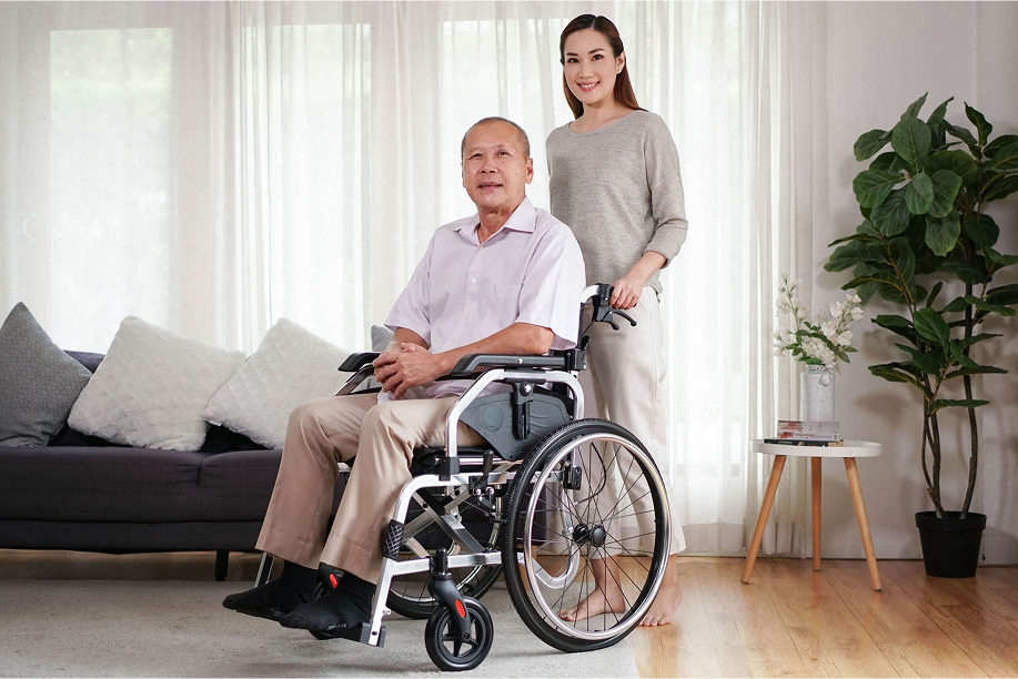 ผู้สูงอายุนั่งวีลแชร์พร้อมคู่ชีวิตภายในบ้าน